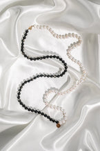 Load image into Gallery viewer, Elegant long handknotted pearl collier necklace with freshwater pearls and goldsheen obsidan. Presented on white silk fabric.